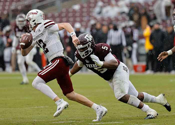 COLLEGE STATION, TEXAS - NOVEMBER 19: Brady Olson #12 of the Massachusetts Minutemen scrambles top avoid being tackled by Shemar Turner #5 of the Texas A&M Aggies during the fourth quarter at Kyle Field on November 19, 2022 in College Station, Texas. (Photo by Bob Levey/Getty Images)
